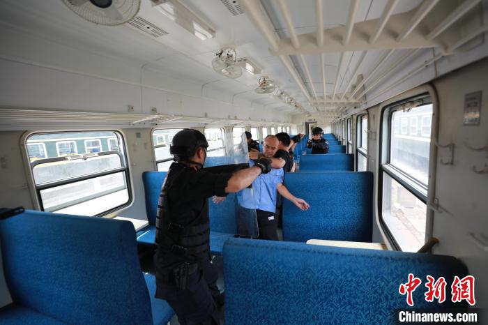 特警成员在列车内演练制服“匪徒”。　毛怀 摄