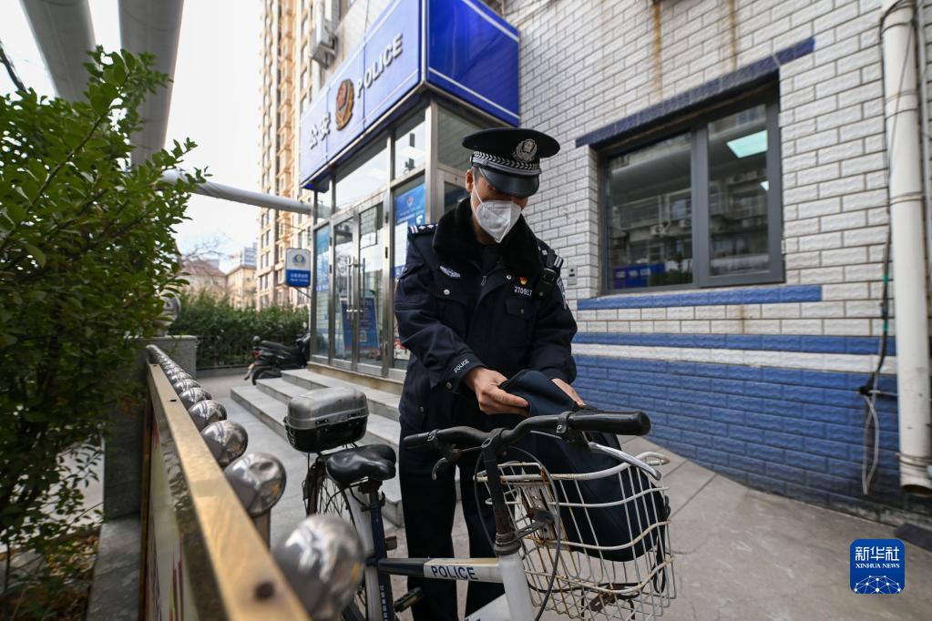 新春走基层丨骑自行车服务社区居民的民警老陈