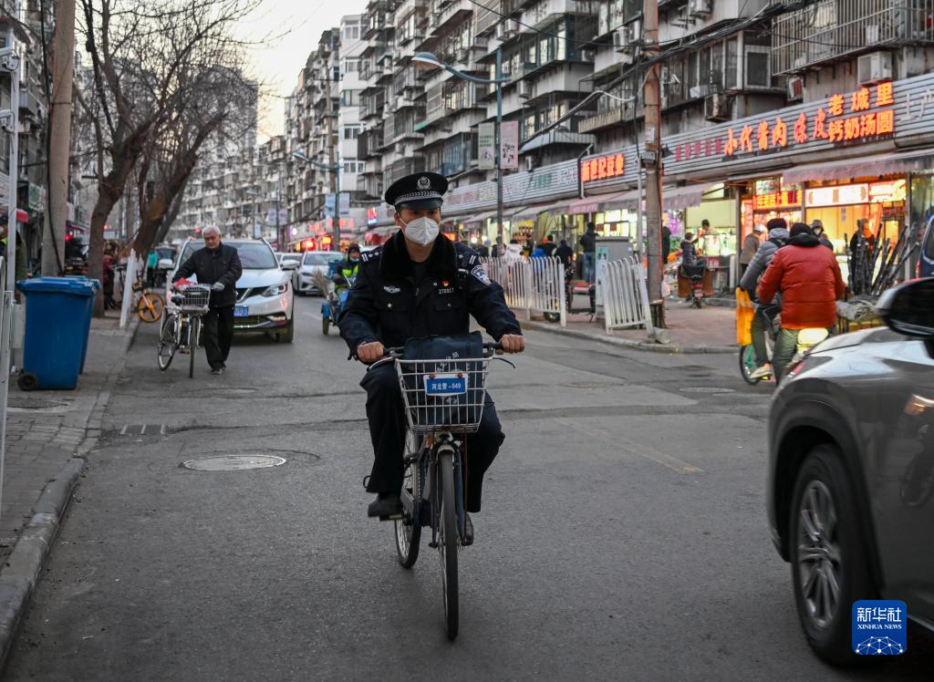 新春走基层丨骑自行车服务社区居民的民警老陈